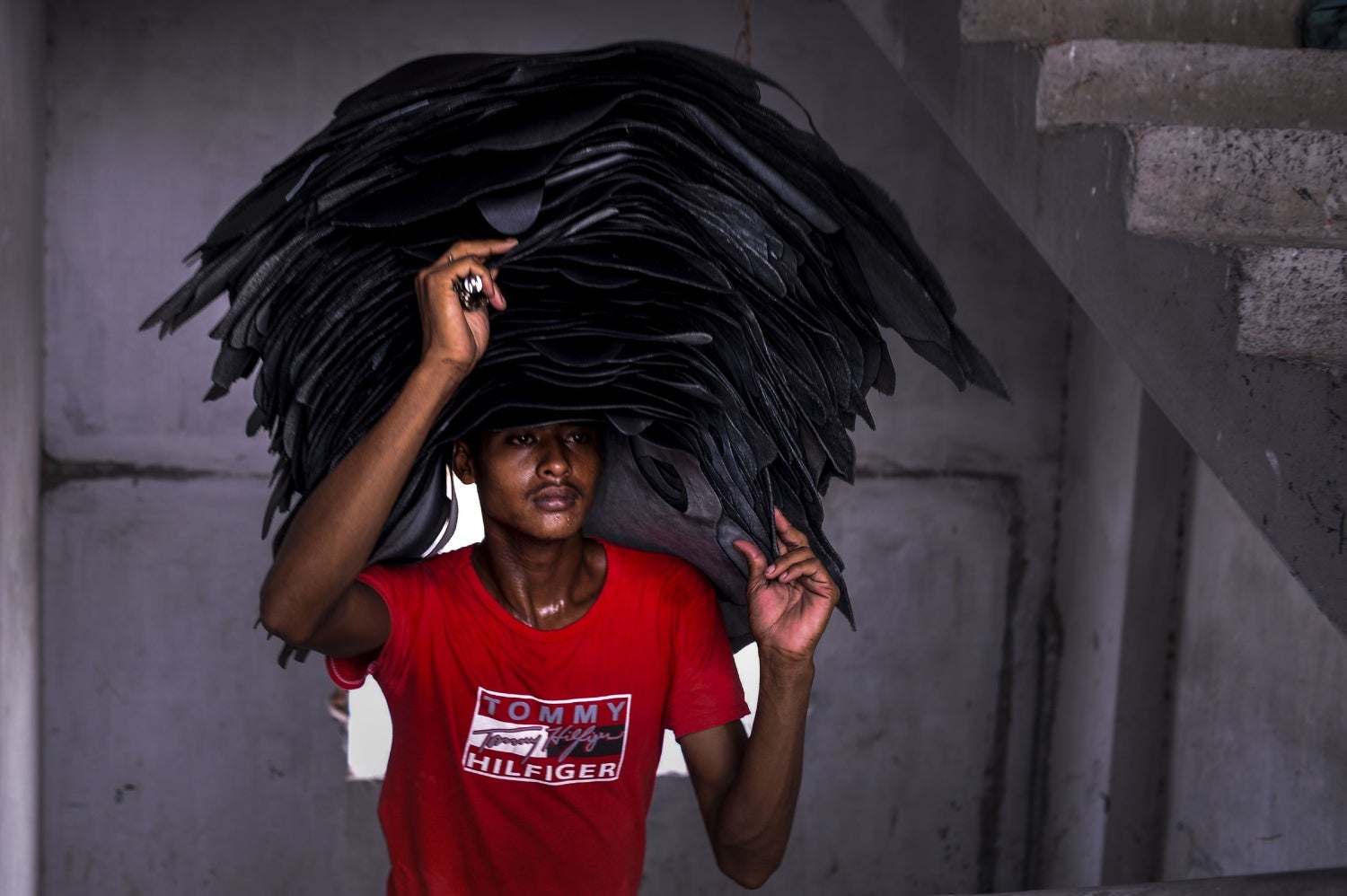 Un trabajador de Bangladesh lleva tiras de cuero en una curtiduría en Dhaka.