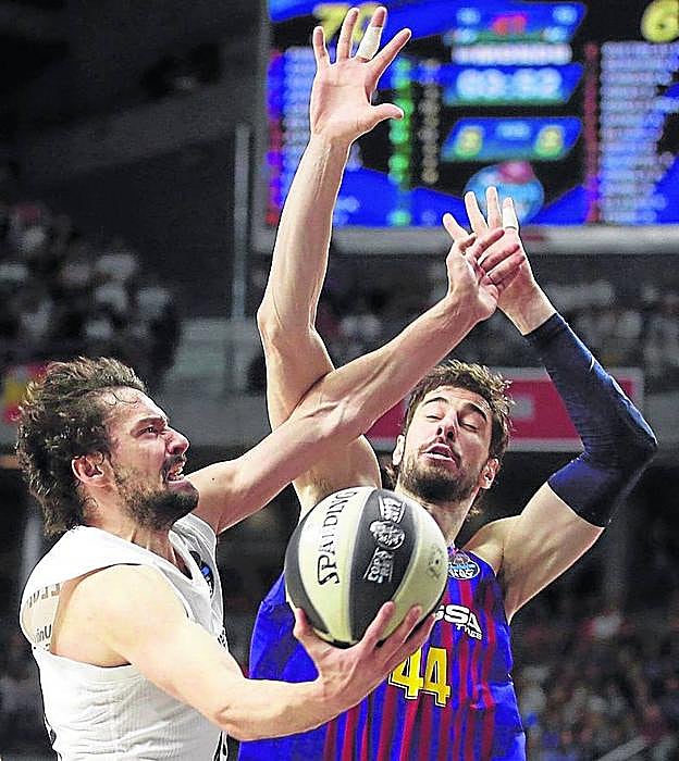 Sergio Llull aparta el brazo de Ante Tomic para evitar un tapón.