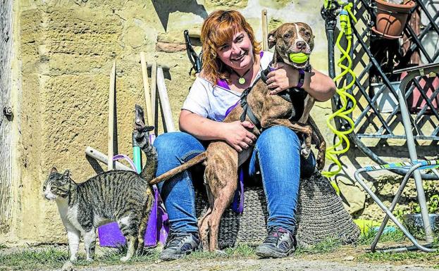 María abraza a Frambuesa, la pitbull que da nombre a este santuario repleto de gatos y gallinas.