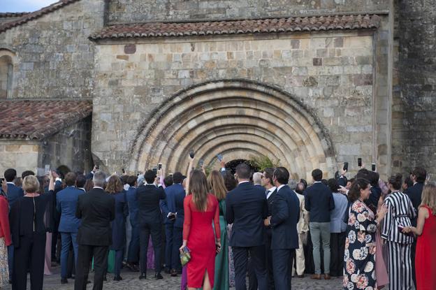 Invitados a la salida de la ceremonia con los móviles en alto para grabar.