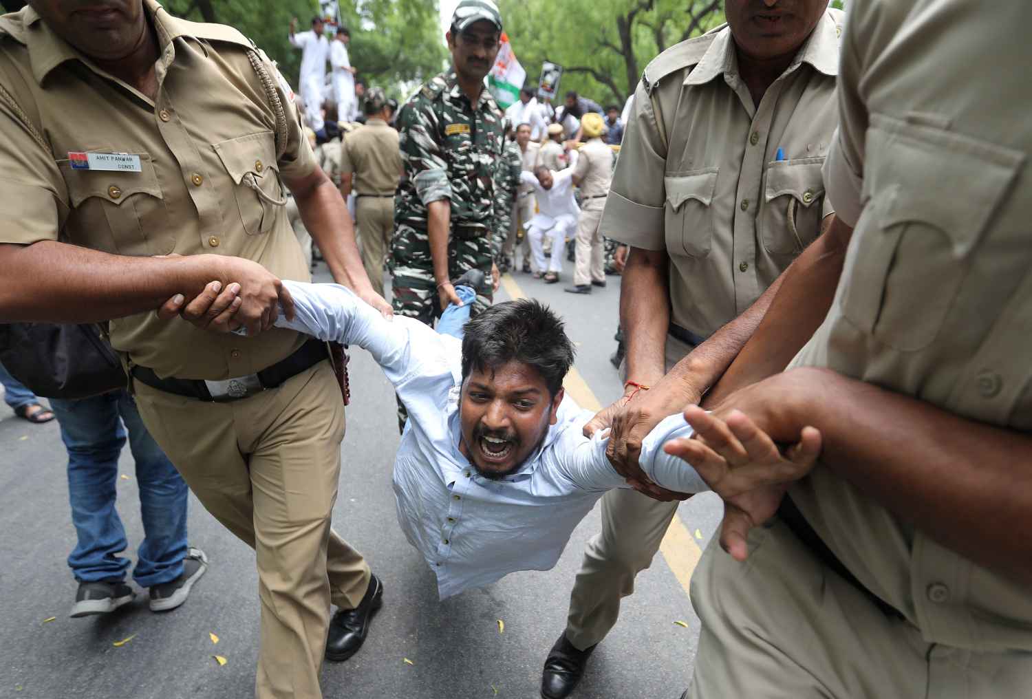 Miembros de las fuerzas de seguridad detienen a un activista durante una protesta contra la muerte de varios niños en el estado de Bihar por un brote de encefalitis en Nueva Delhi (India). Más de 150 menores murieron a causa de la enfermedad, según medios locales. 