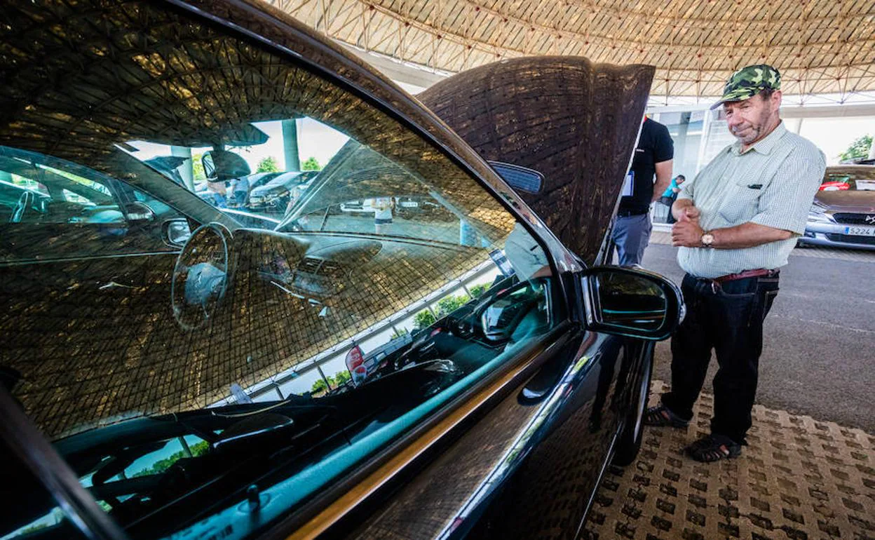 Un hombre revisa un coche bajo la cúpula del Buesa.