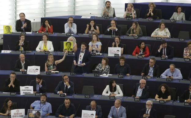 Algunos diputados portan carteles en apoyo a Puigdemont y Comín.