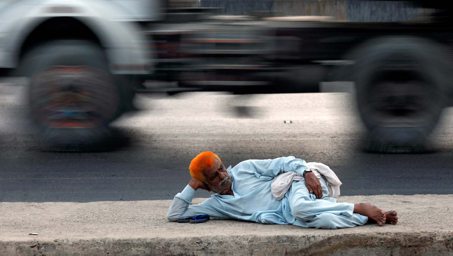 Un hombre descansa en una carretera cerca del área del puerto en Karachi, Pakistán.