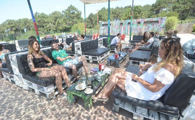 Varios jóvenes se relajan en el chiringuito Fangaloka, en la playa de Aizkorri.