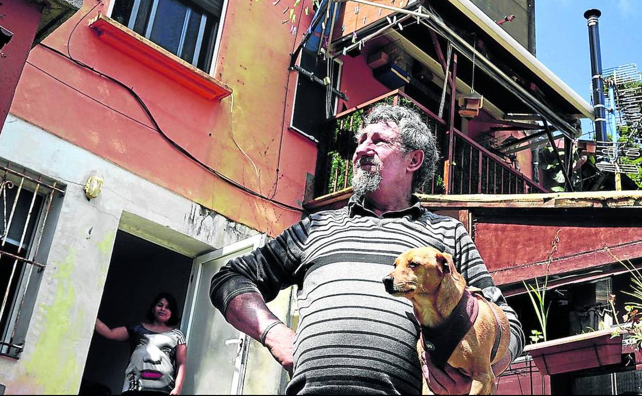 José Luis Santos, en la imagen con su perro 'Conan' y al fondo su mujer Laura, compró la casa en el barrio de Betolaza hace 41 años.