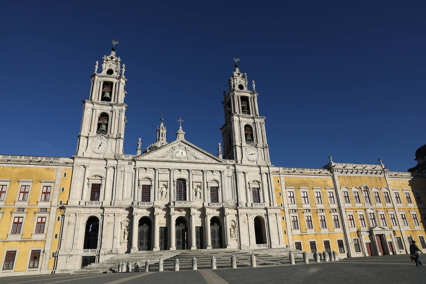 Palacio de Mafra. Con esta construcción, Portugal puede presumir de contar con dos nuevos sitios en la lista de nuevas maravillas de la Unesco. Este palacio se sitúa a 30 kilómetros al noroeste de Lisboa y fue proyectado por el rey Juan V en 1711 para plasmar su concepción de la monarquía y el Estado. El edificio hizo el papel de palacio real, capilla regia, monasterio franciscano y biblioteca, que en la actualidad atesora unos 36.000 libros.