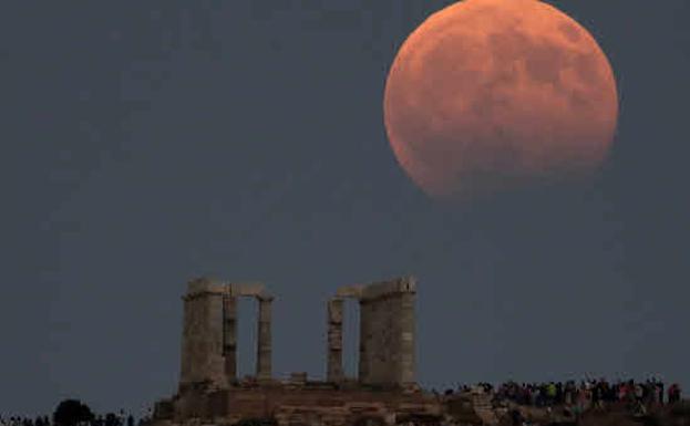 Eclipse lunar parcial visto junto al Templo de Poseidón en el cabo de Sunión .