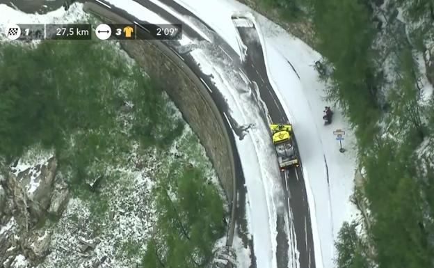 Un quitanieves trata de apartar la capa de granizo que ha caído en la etapa de este viernes del Tour de Francia.