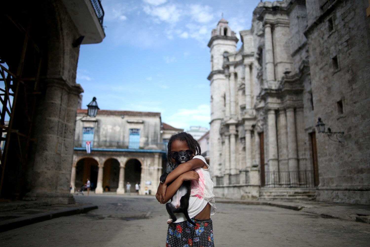 Una niña pequeña posa para una foto con su perro a las puertas de la Catedral de La Habana, en La Habana, Cuba.