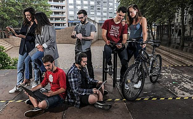 Un grupo de veinteañeros utiliza sus aparatos tecnológicos en Vitoria. 