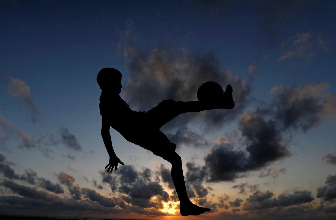 Un niño patea una pelota de fútbol en una playa de Colombo, Sri Lanka