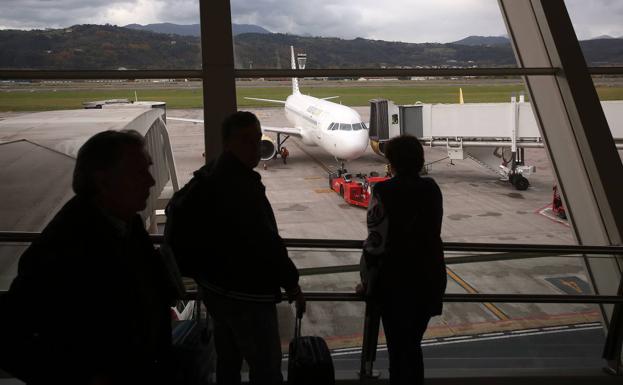 Aeropuerto de Loiu, pasajeros observando un avión estacionado.