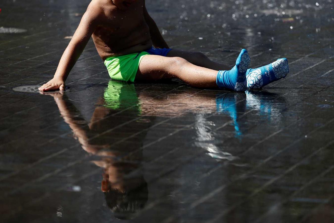 Un niño se refresca en los chorros de agua de la playa de Madrid Río