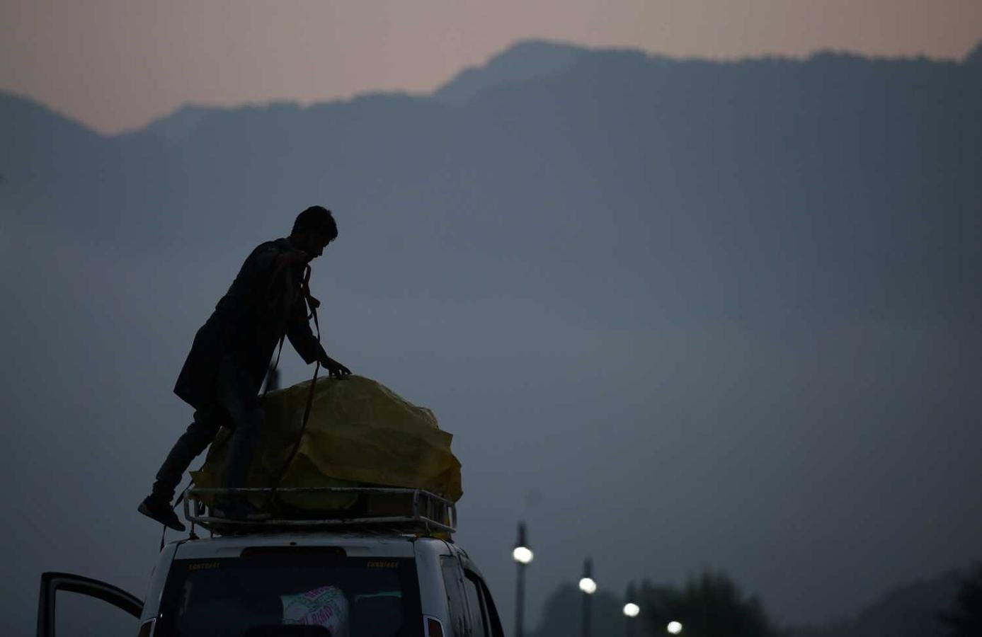 Un niño carga el equipaje de turistas en Srinagar. India