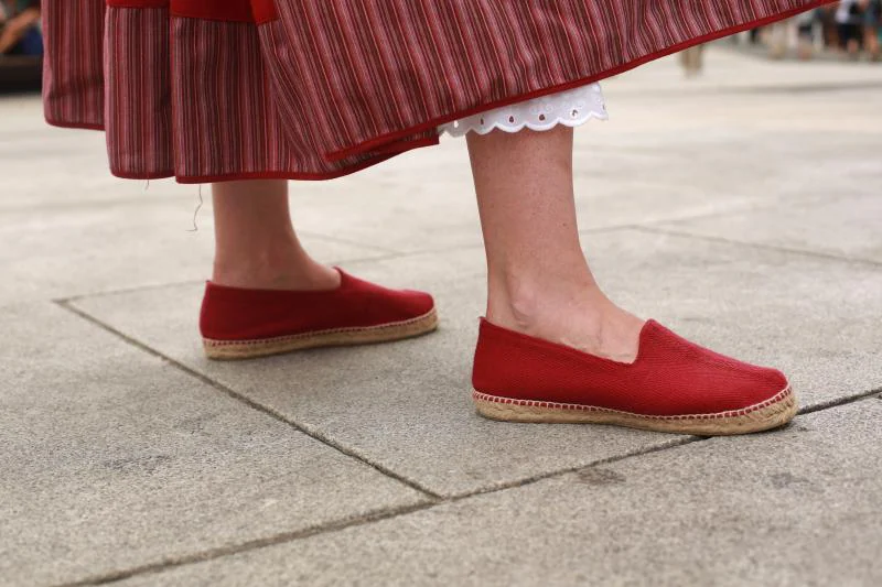 Maribel Bahillo lleva un traje de neska en tonos rojos con un lauburu bordado, moño con pañuelo a juego y alpargatas.