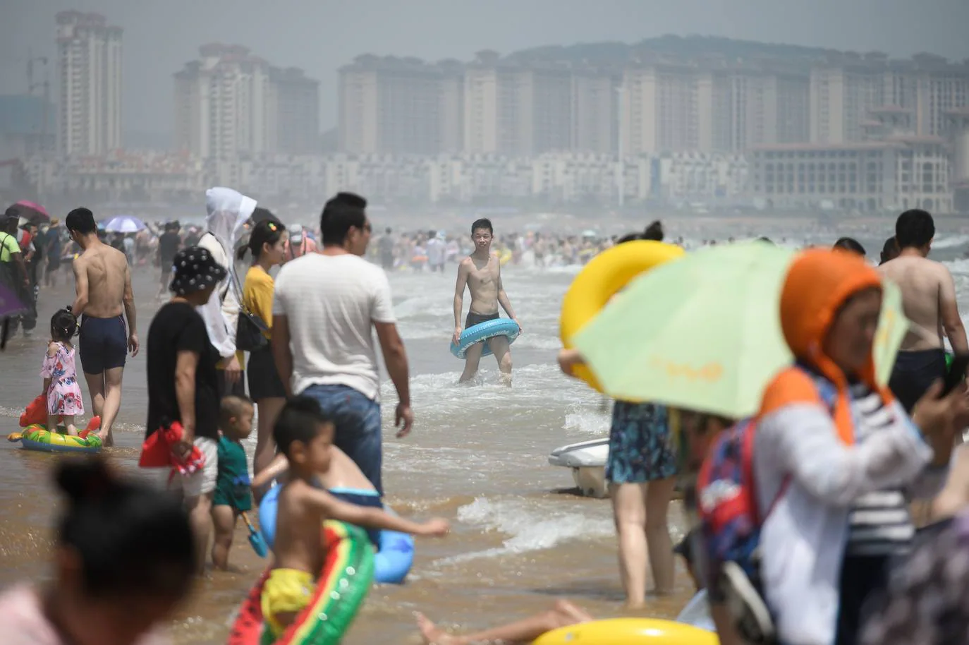 La playa de Qingdao en la provincia de Shadong, es una de las playas más concurridas de China. Aquí, la gente, busca un lugar donde refrescarse del azotador calor