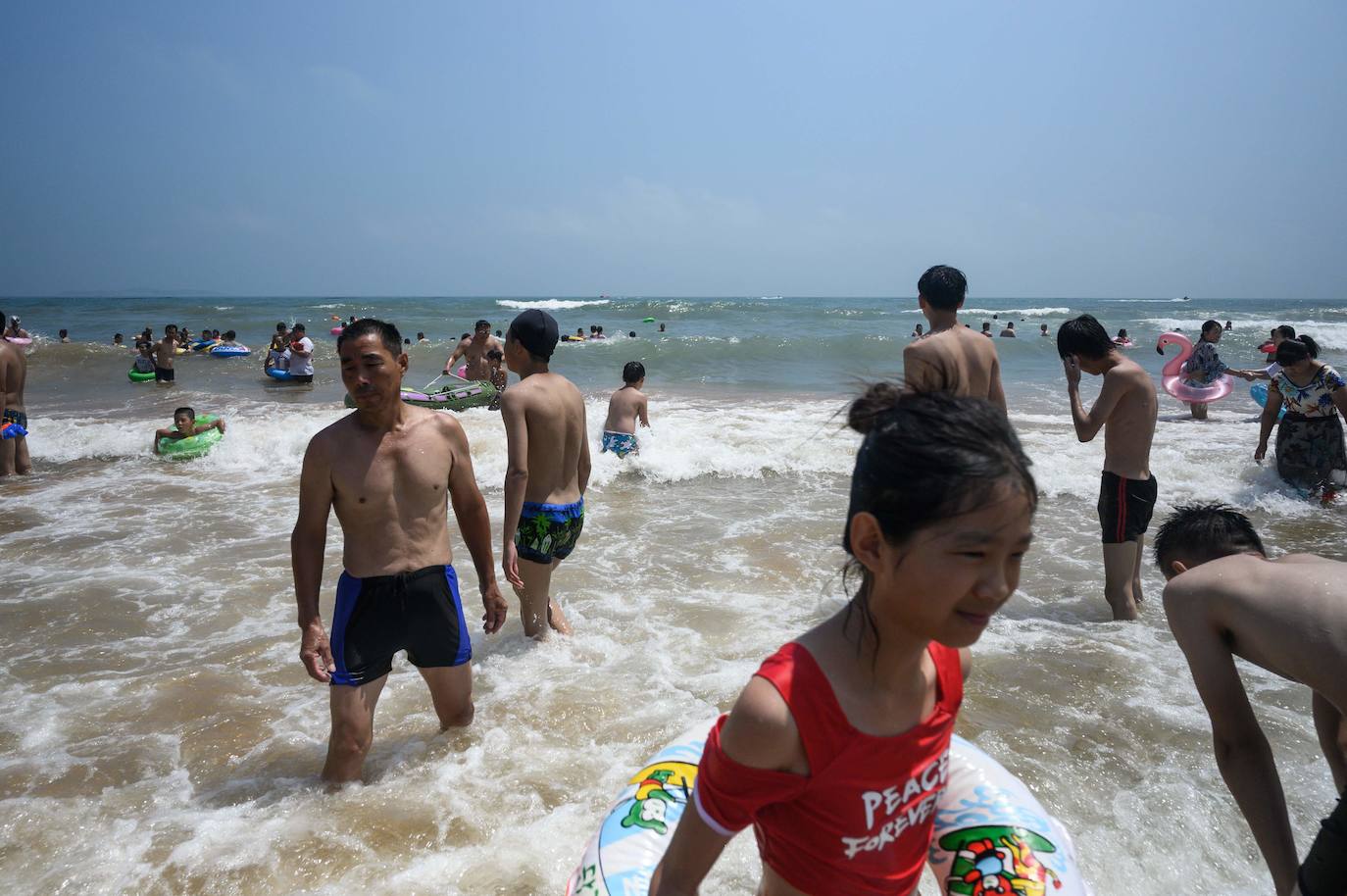 La playa de Qingdao en la provincia de Shadong, es una de las playas más concurridas de China. Aquí, la gente, busca un lugar donde refrescarse del azotador calor