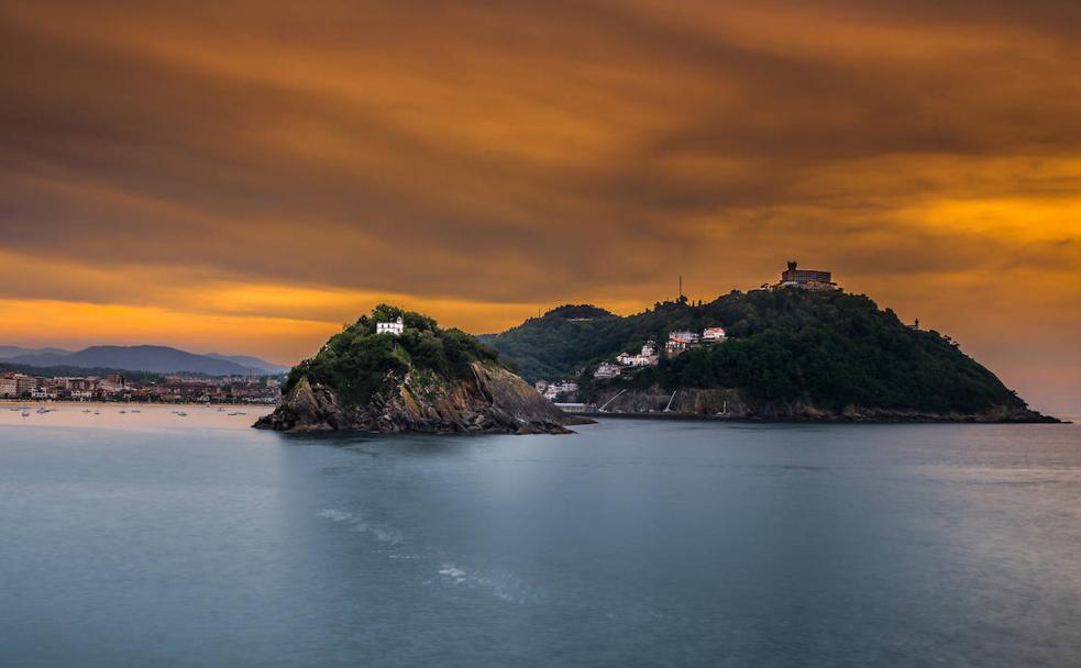 Los colores del atardecer envuelven la isla de Santa Clara. Detrás, a la derecha, el monte Igeldo. 