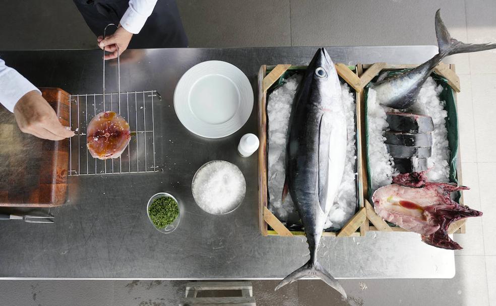 El cocinero del Katxiña (Orio) sala un bonito previamente despiezado.