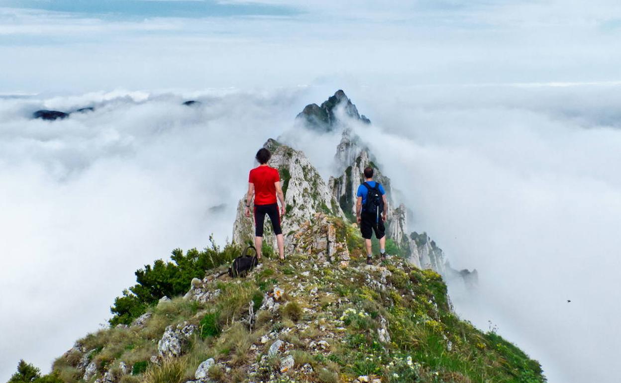 Dos montañeros crestean la cima de Monte Larrasa. 