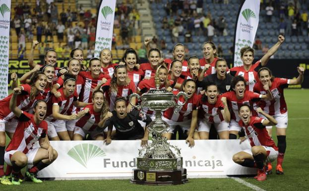 Las rojiblancas posan con el trofeo.