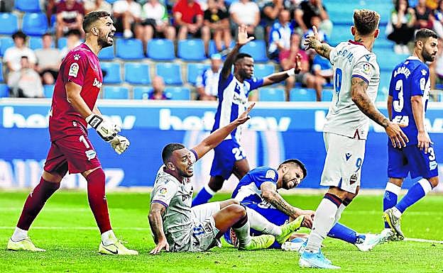 El portero alavesista arenga a la defensa con el levantinista Vezo, al que hizo una gran parada con el pie, sobre el césped.