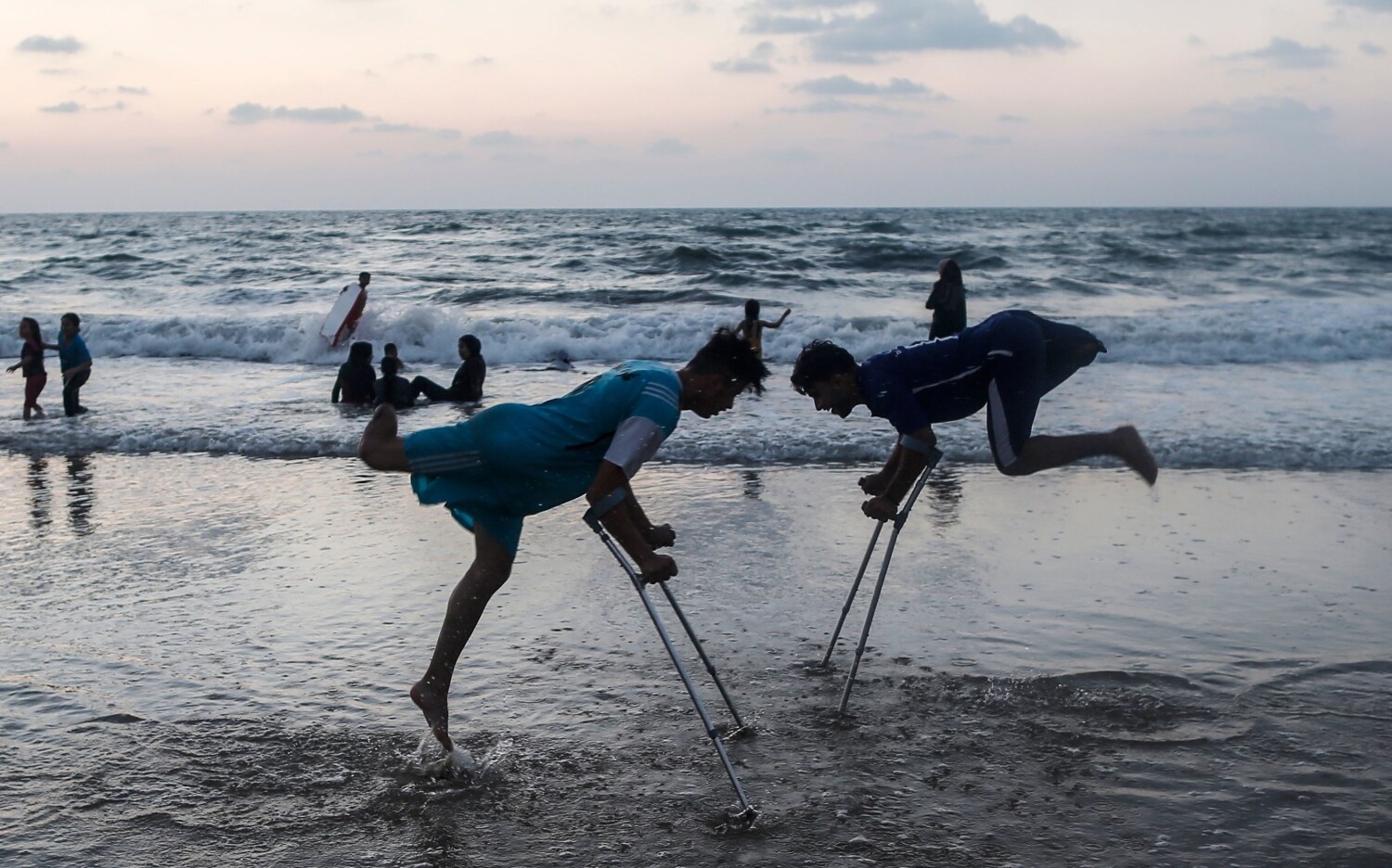 Los amputados palestinos Mohammed Eliwa, de 17 años, y Ahmed al-Khoudari (R), de 20 años, que perdieron las piernas durante los enfrentamientos en la frontera con Israel, juegan en la playa en la ciudad de Gaza.