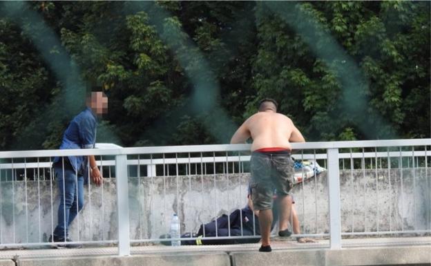 El bombero, en el suelo, hablando con el hombre para que no se lanzara.