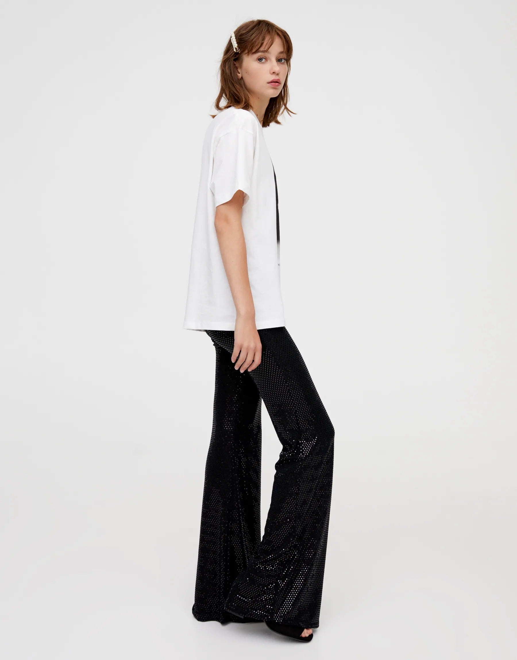 29. Las lentejuelas le dan brillo a estos pantalones negros de campana de Pull & Bear (19,99 euros). Se ajustan a la perfección a la figura de la mujer. 