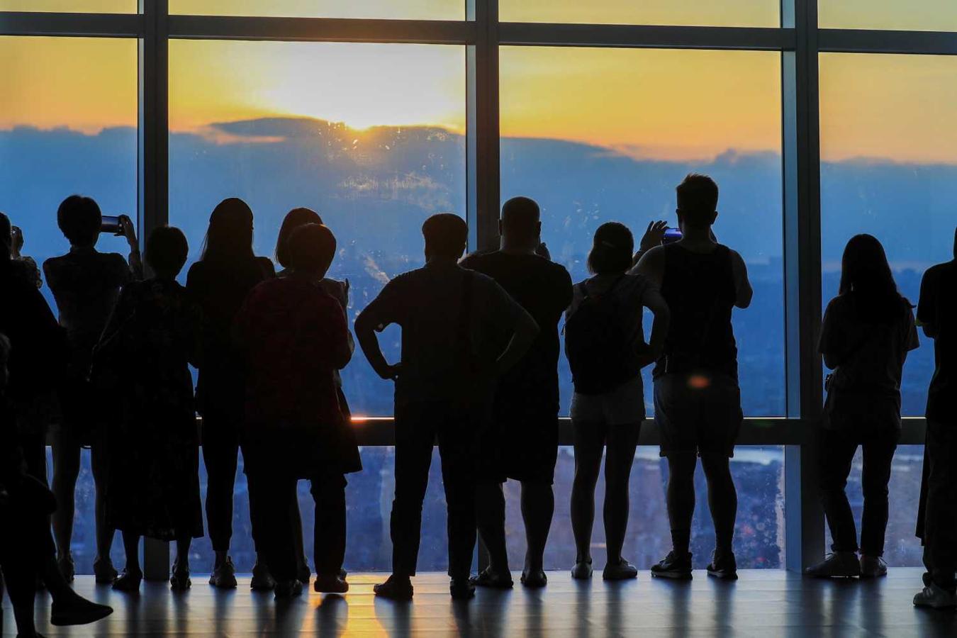 Turistas observan una puesta de sol en el observatorio del rascacielos Taipéi 101, en Taiwán