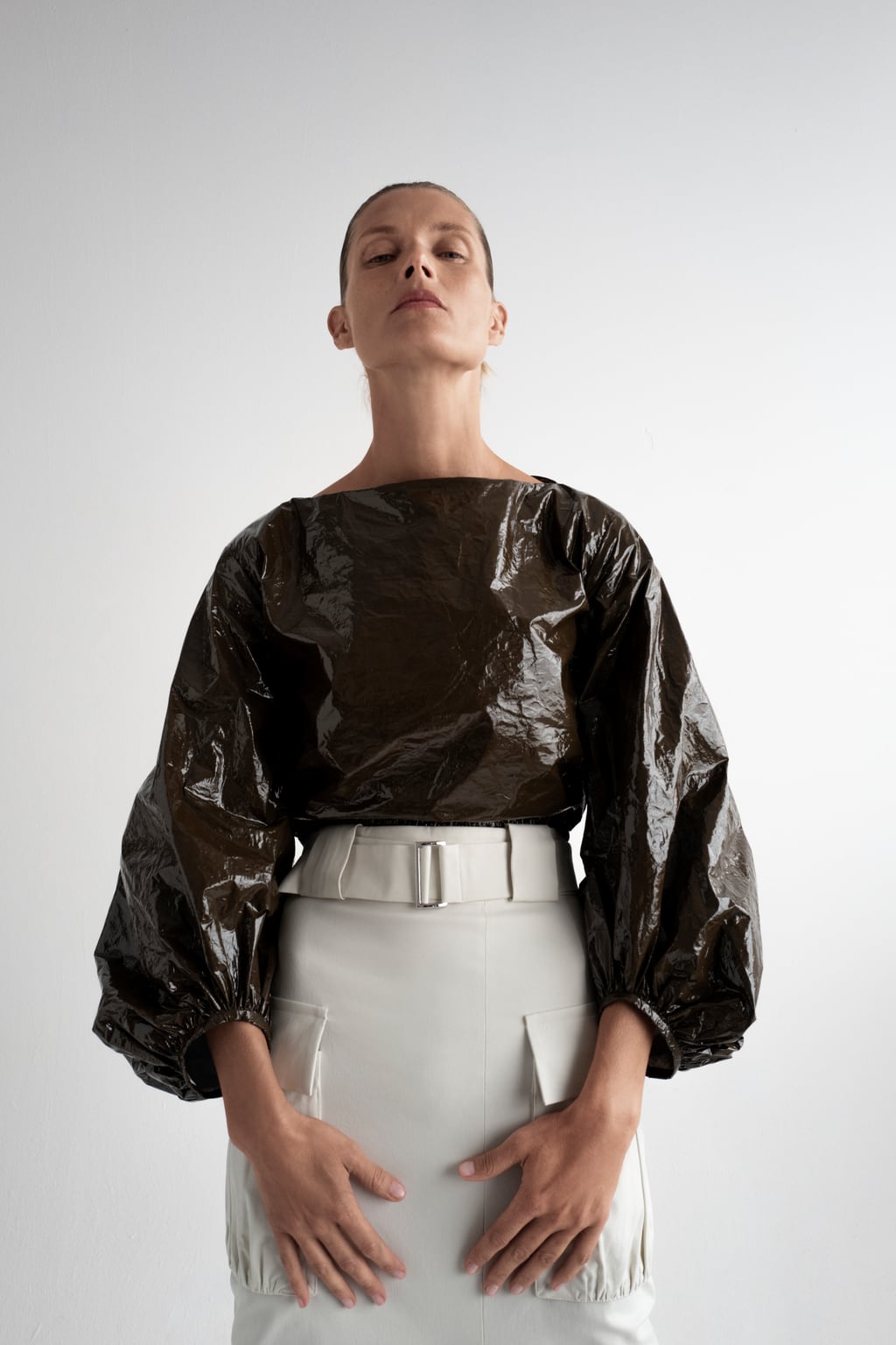 Blusa con mangas XL y efecto plastificado, de Zara (49,95 euros).