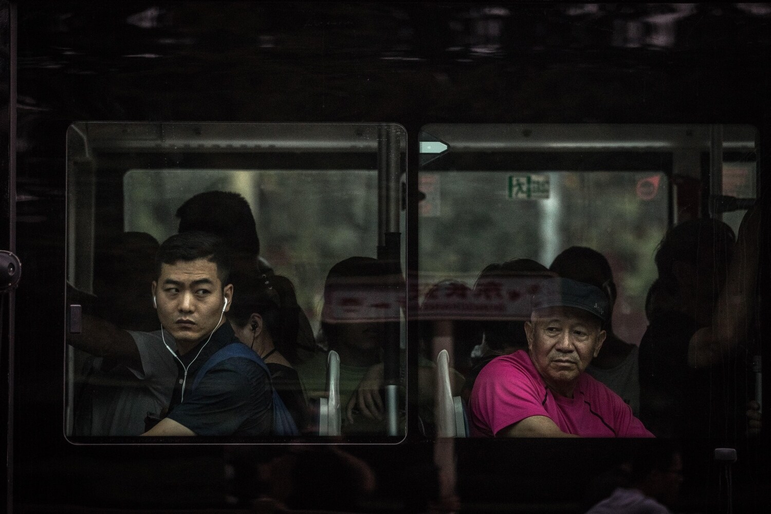 Dos pasajeros observan la calle a través de los ventanales de un autobús, en la plaza de Tiananmen (China). En medio de unas fuertes medidas de seguridad, Pekín se prepara con varias semanas de antelación para la jornada que celebra el 70 aniversario de la fundación de la República Popular China, el próximo 1 de octubre. 