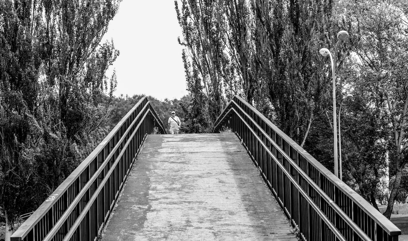 Un hombre camina sobre el puente que conecta el barrio con el parque de Arana.