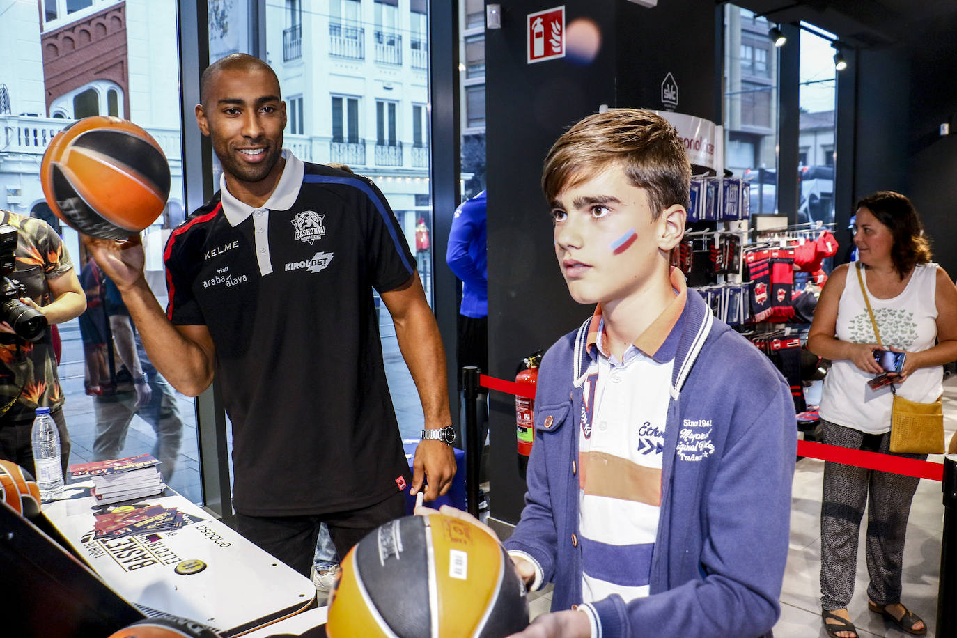 Encuentro con la afición. Los jugadores del Baskonia entraron uno a uno en la sede de General Álava tras saludar a los aficionados. Una vez dentro firmaron autógrafos y jugaron con los más pequeños en una sesión de puro hermanamiento baskonista