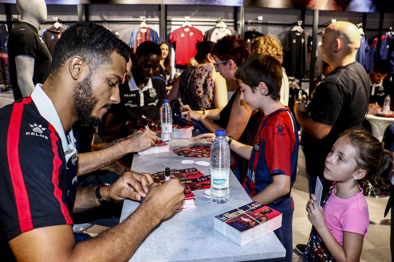 Encuentro con la afición. Los jugadores del Baskonia entraron uno a uno en la sede de General Álava tras saludar a los aficionados. Una vez dentro firmaron autógrafos y jugaron con los más pequeños en una sesión de puro hermanamiento baskonista