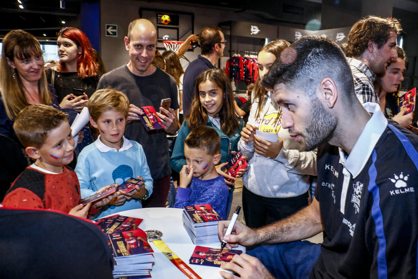 Encuentro con la afición. Los jugadores del Baskonia entraron uno a uno en la sede de General Álava tras saludar a los aficionados. Una vez dentro firmaron autógrafos y jugaron con los más pequeños en una sesión de puro hermanamiento baskonista