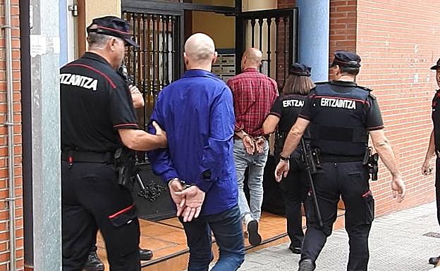 Dos de los detenidos entran junto a la Ertzaintza en el piso de Atxuri.