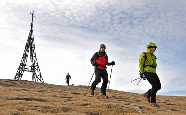 Dos montañeros emprenden el descenso desde la cima del Gorbea. 