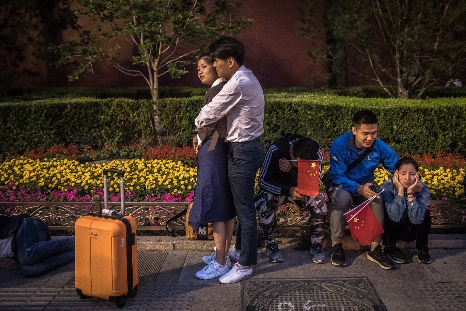 Ciudadanos chinos esperan la ceremonia de izada de la bandera nacional cerca a la plaza de Tiananmen en Pekín (China). 