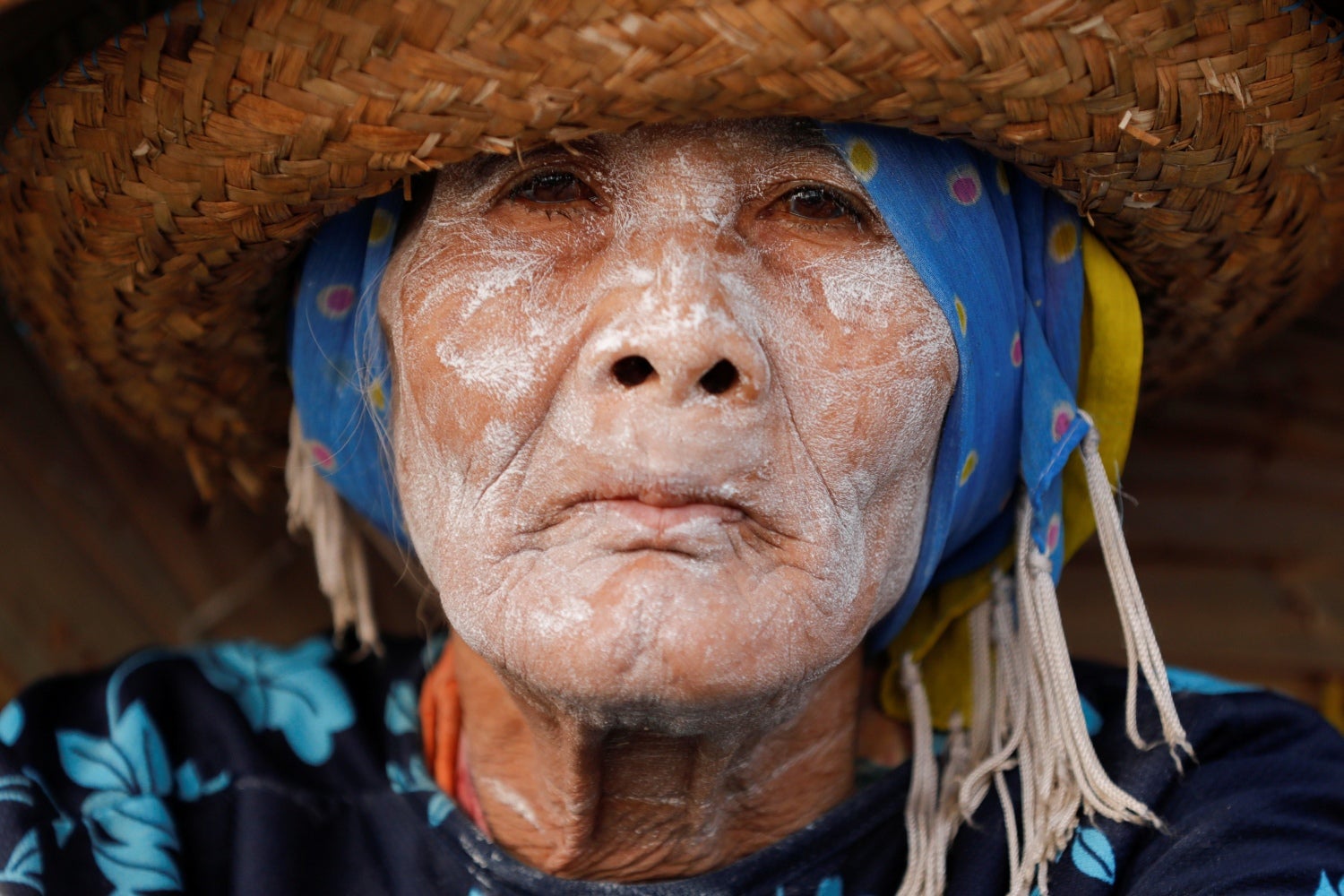 Una mujer con cara la cubierta de polvo para refrescarse, observa mientras vende frutas y verduras en un bote de madera en el río Martapura en el pueblo de Lok Baintan cerca de Banjarmasin, provincia de Kalimantan del Sur, Indonesia. 