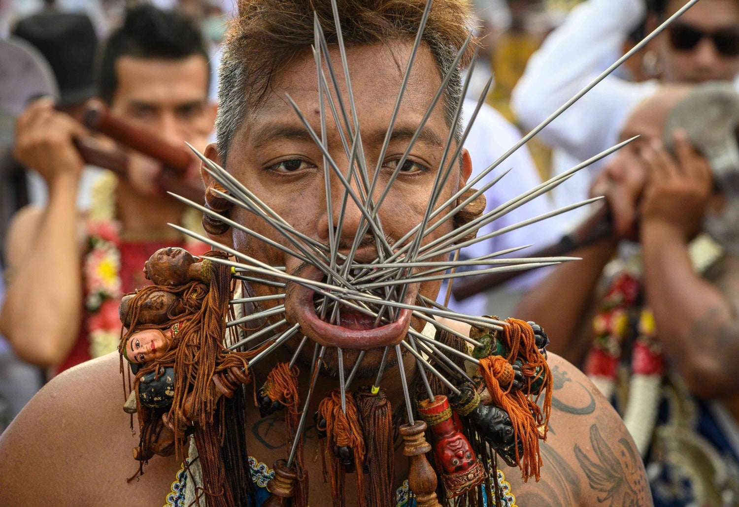 Un devoto de un santuario chino con múltiples pinchos perforados en sus mejillas participa en una procesión durante el Festival Vegetariano anual en Phuket, Tailandia. El festival comienza la primera tarde del noveno mes lunar y dura nueve días, con muchos devotos religiosos cortándose con espadas, perforando sus mejillas con objetos afilados y cometiendo otros actos dolorosos para purificarse, asumiendo los pecados de la comunidad