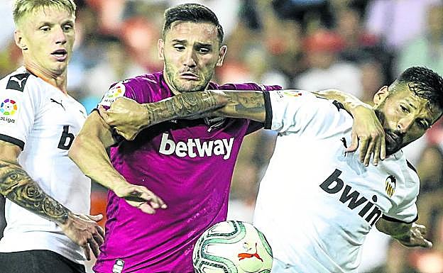 Lucas Pérez pelea por la pelota con Garay en el partido del sábado en Mestalla. 