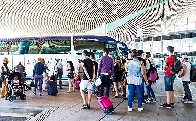 Un grupo de viajeros espera a su autobús.