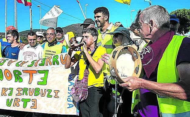 Ana Martínez, y los jóvenes de Apafam, con un cartel en euskera.