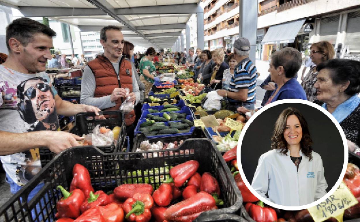 Clientes compran en el mercado de Santa Bárbara. A la derecha, Ainhoa Sáez de Vicuña