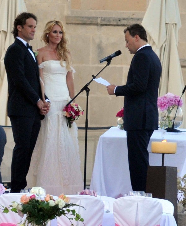 Carolina Cerezuela es la mujer de Carlos Moyá y se casaron un jueves cualquiera de julio en el ayuntamiento de Llucmajor, en Mallorca, allá por 2011, cuando ya tenían a su primera hija en común. La actriz alicantina eligió un diseño de la firma española Yolancris, una de las más aplaudidas hoy dentro del panorama nupcial internacional. Era el modelo ‘Gilda’, un diseño de temporadas anteriores, corte romántico y escote palabra de honor rematado con unos tirantes muy finos que caen sobre los brazos. Estaba confeccionado con un juego de puntillas de encaje chantillí en el cuerpo y una falda voluminosa con un doble volante de tul y seda plisada en la parte posterior.