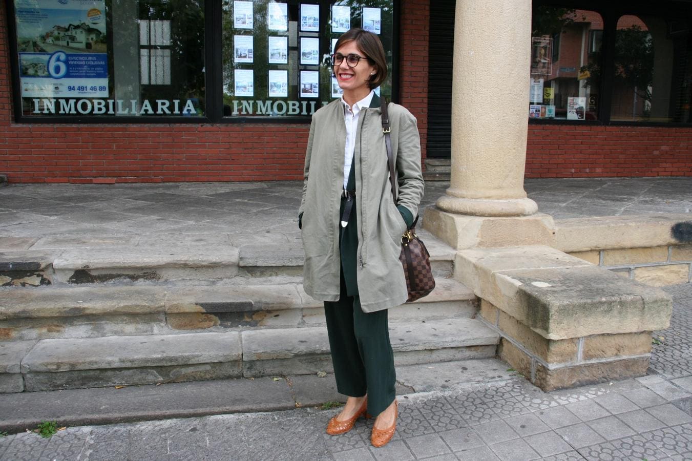 Elena Muguerzo, de 41 años y de Neguri, es toda una profesional en construir estilismos que brillan por sí mismos. Se compró el 'outfit' en una tienda de Eibar llamada Cedry. Y se compone de un traje de dos piezas en verde oscuro, una camisa blanca y una chaqueta. Completa el look con un bolso de Louis Vuitton y unos zapatos de tacón en color mostaza que adquirió en una tienda de la calle bilbaína Alameda Recalde. 