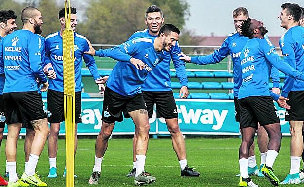Los jugadores del Alavés, con Joselu y Wakaso en el centro, bromean durante el inicio del entrenamiento de ayer en Ibaia.