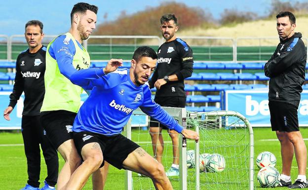 Joselu protege el balón ante Burgui bajo la atenta mirada de Asier Garitano y su cuerpo técnico.